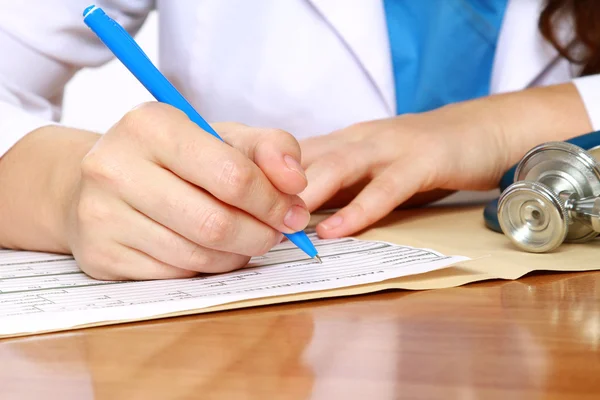 A female doctor is fiiling a prescription — Stock Photo, Image