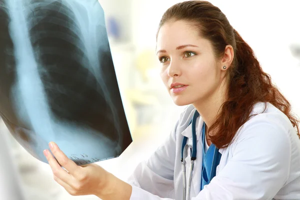 Een vrouwelijke arts bestudeert x-ray — Stockfoto