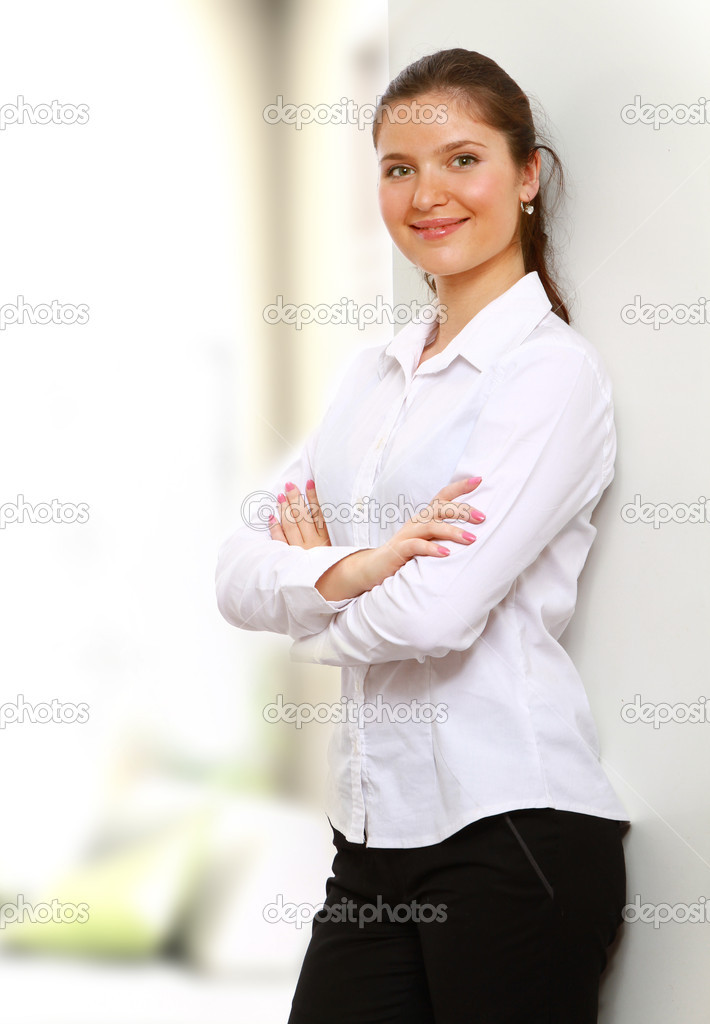 A businesswoman standing near the wall indoors