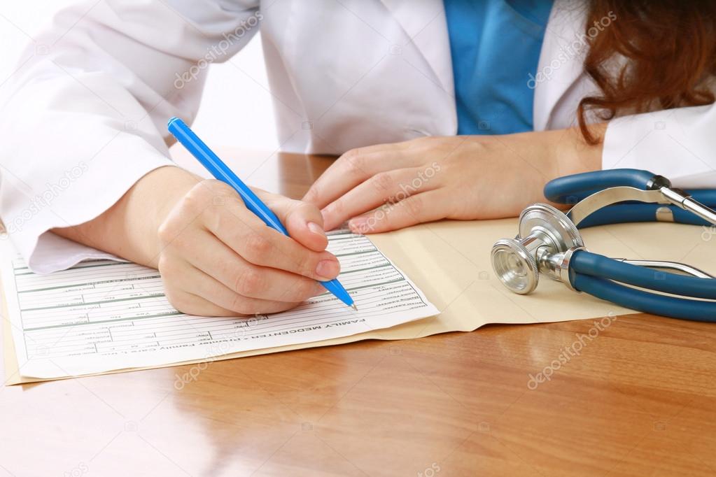 A female doctor is fiiling a prescription