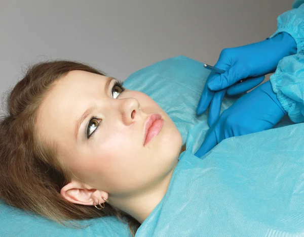 Doctor with a sculpel and a patient — Stock Photo, Image