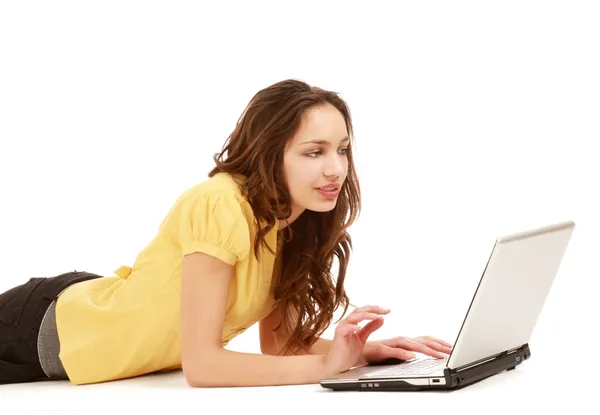 A woman with a laptop lying on the floor — Stock Photo, Image