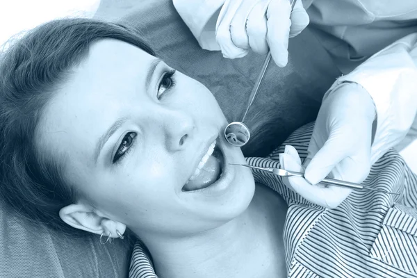 Un dentista examinando los dientes de un paciente , — Foto de Stock