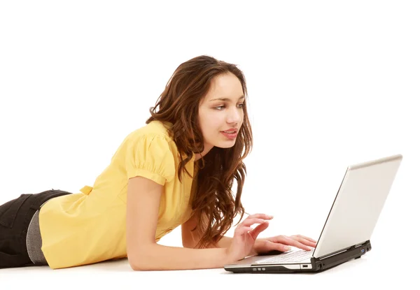 A woman with a laptop lying on the floor Stock Image