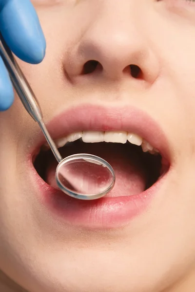 Um dentista examina os dentes do paciente — Fotografia de Stock