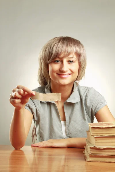 Une femme souriante tenant un morceau de papier vide — Photo