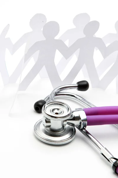 A close-up of a stethoscope and paper people — Stock Photo, Image