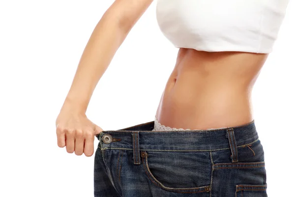 Young slim woman in oversized pair of jeans — Stock Photo, Image