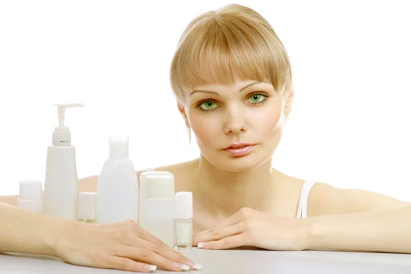 Uma jovem mulher com produtos cosméticos — Fotografia de Stock