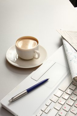bir fincan kahve, kağıt ve kalem bir laptop