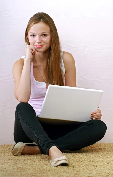 Mulher em tanque-top relaxante com seu laptop — Fotografia de Stock