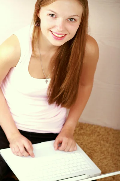 Teenage girl sitting on carpet — Stockfoto