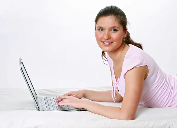 Femme couchée sur le lit avec ordinateur portable — Photo