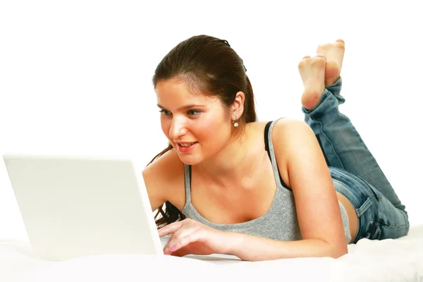 Ragazza sdraiata sul divano con laptop — Foto Stock