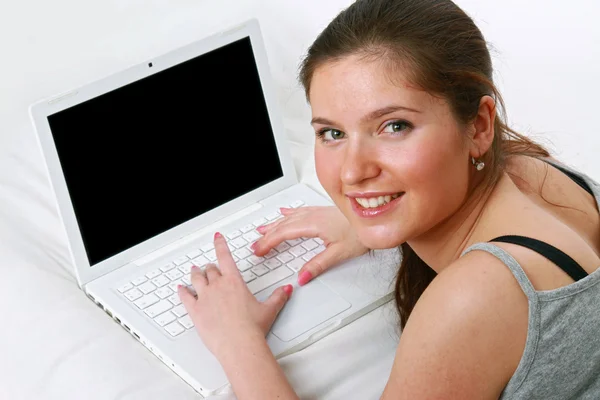 Close-up of smiling girl typing — Stock Photo, Image