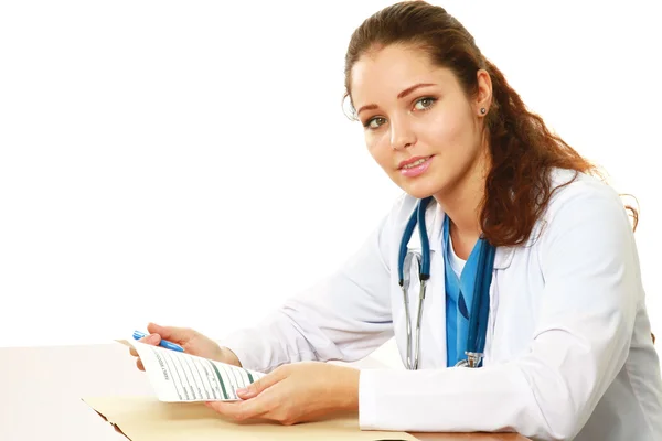 Young doctor with stethoscope sitting at desk — Stock Photo, Image