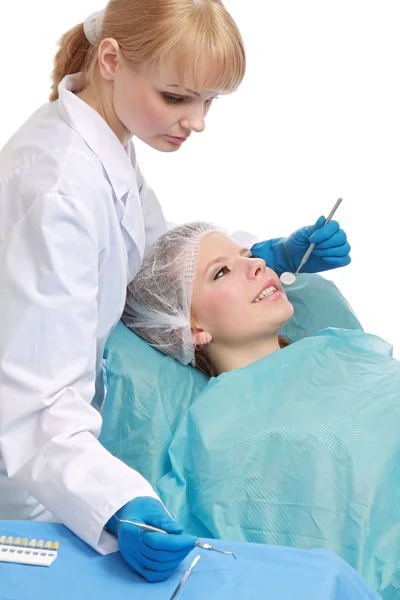 Jovem dentista examinando os dentes de seu paciente — Fotografia de Stock