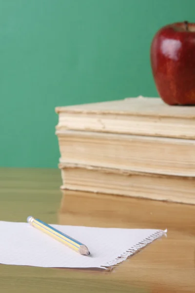 Книги, яблоко и лист бумаги — стоковое фото