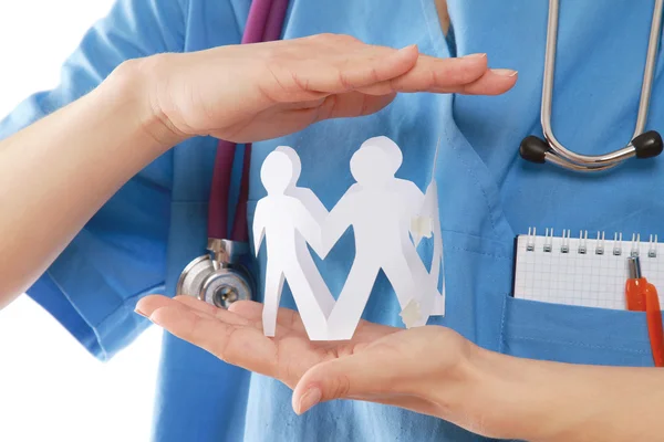 A female doctor holding paper people — Stock Photo, Image