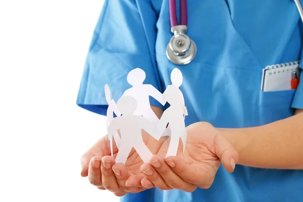 A female doctor holding paper people — Stock Photo, Image