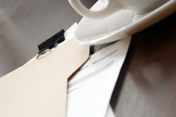 En vit kopp och en mapp med papper — Stockfoto