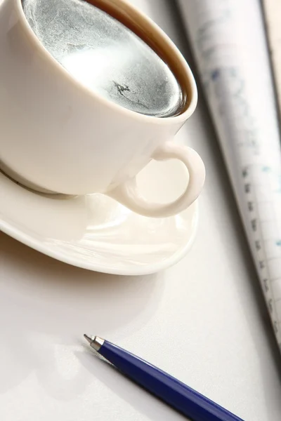 Una tazza bianca di cappuccino e una penna blu — Foto Stock