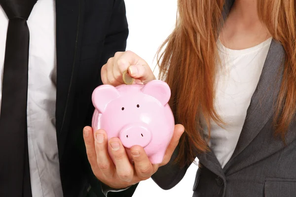 Businesswoman and man putting a coin into a piggy bank i — Stock Photo, Image