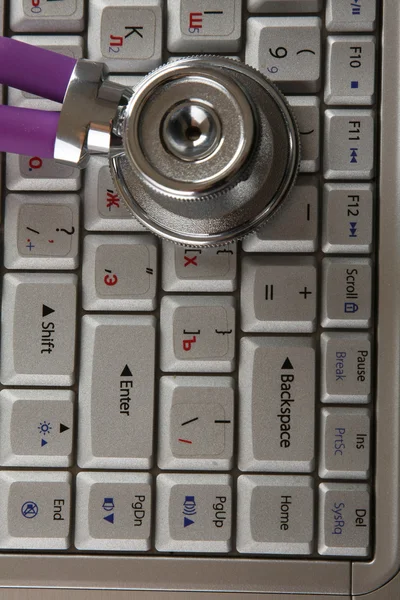 Een stethoscoop op een toetsenbord — Stockfoto