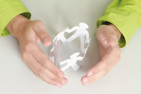 Mannelijke handen het verzorgen van papier mensen — Stockfoto