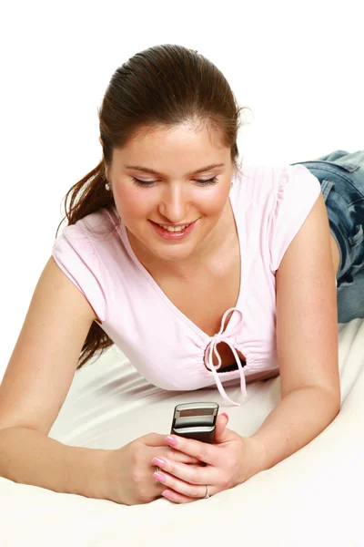 Girl sending a message laying on bed Royalty Free Stock Images