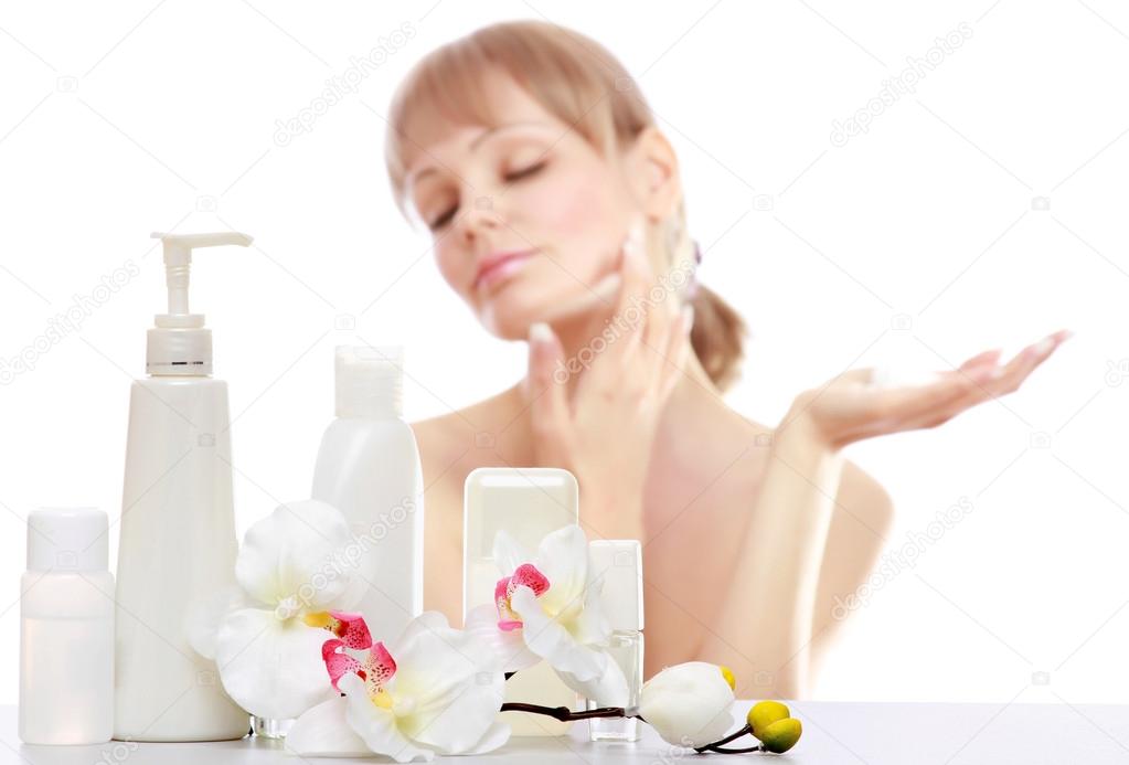 Woman applying cream on her skin
