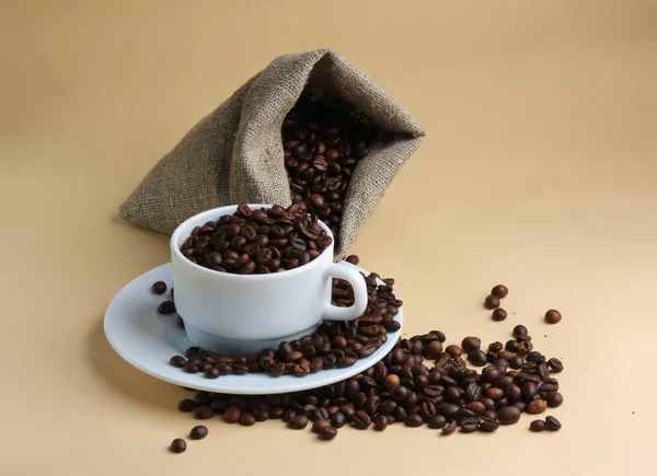 Cup and sack with coffee beans — Stock Photo, Image