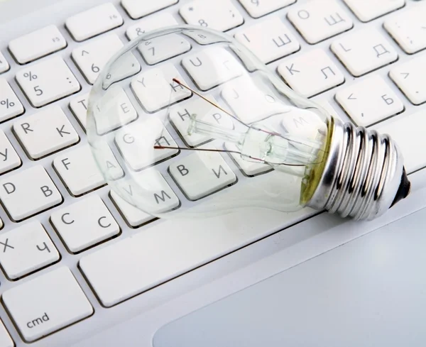 Light bulb and computer keyboard — Stock Photo, Image