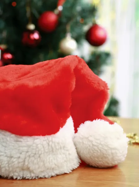 Santa hatt under en julgran — Stockfoto