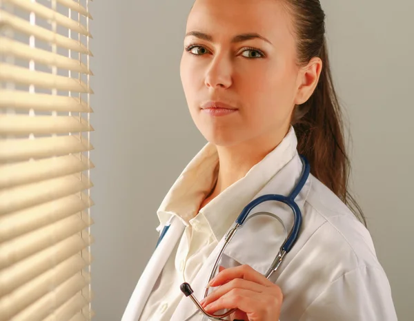 Kvinna läkare står nära fönster. — Stockfoto