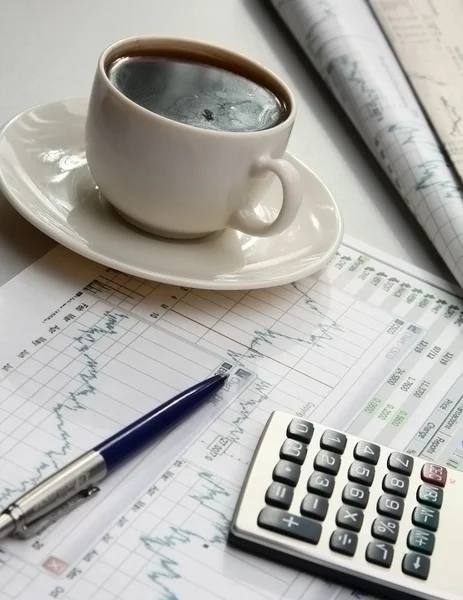 Eine Tasse Kaffee, Papier und einen Stift auf einem Laptop. — Stockfoto