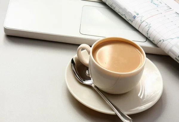 Une tasse de café, papier sur un ordinateur portable . — Photo