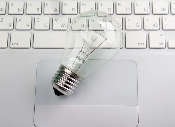 Light bulb and computer keyboard. — Stock Photo, Image