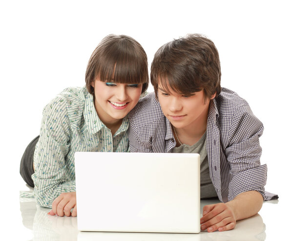 A couple lying on the floor behind a laptop