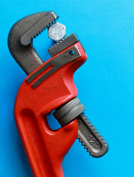 Closeup of adjustable wrench over blue. — Stock Photo, Image