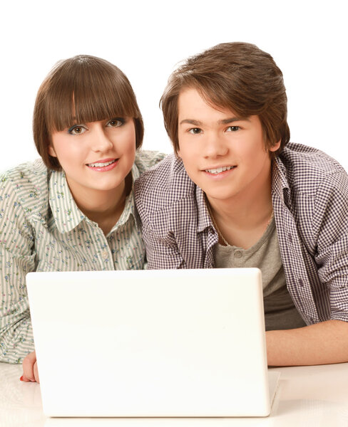A couple lying on the floor behind a laptop