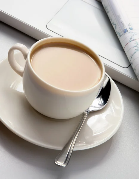 Cup of coffee near the laptop and newspapers. — Stock Photo, Image