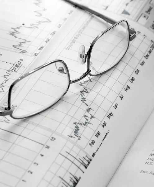 Financial charts and glasses — Stock Photo, Image