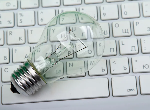 Light bulb and computer keyboard. — Stock Photo, Image