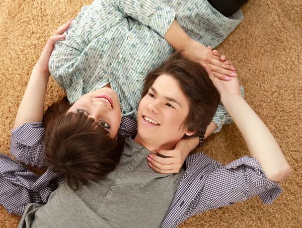 A young couple lying on the floor. — Stock Photo, Image