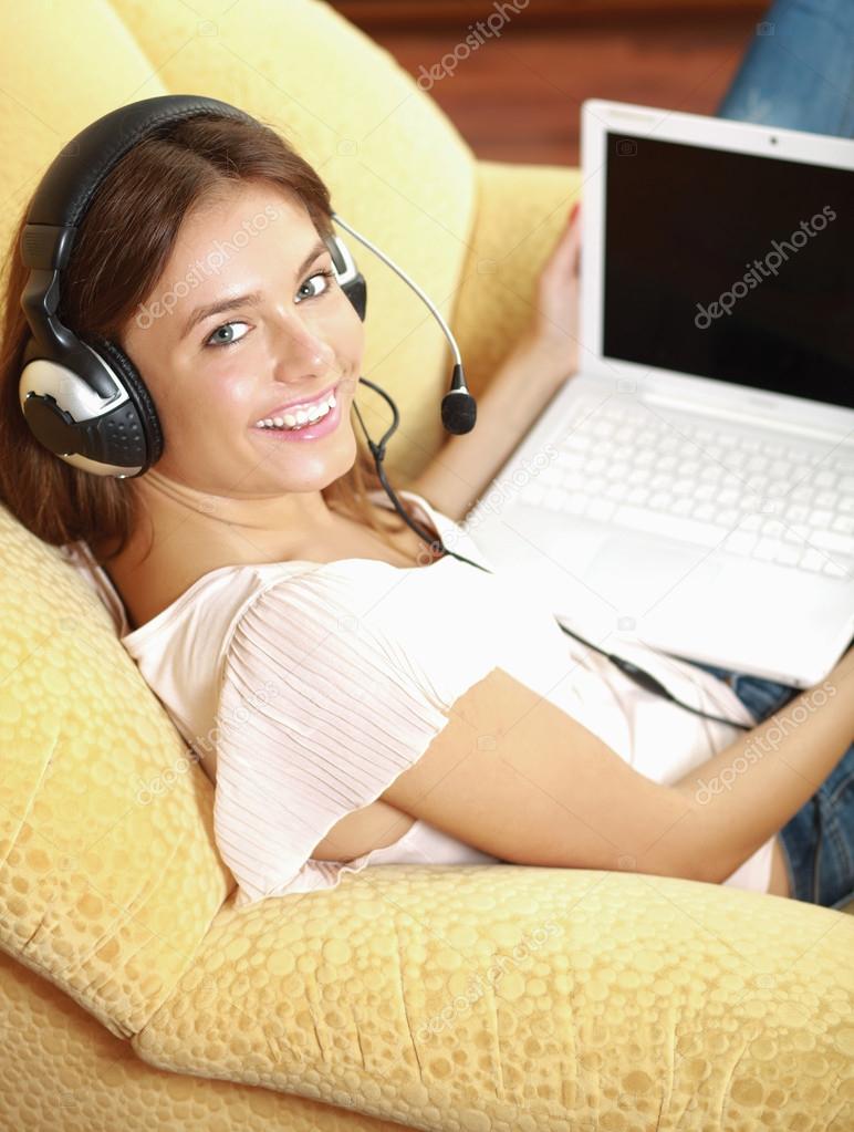 A woman working on a laptop sitting on sofa