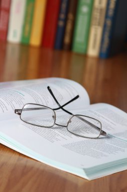 Gözlüklü kitap kitaplar karşı masanın üstüne.