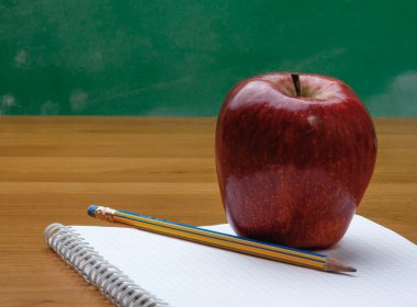 bir defter üstünde Kırmızı elma.