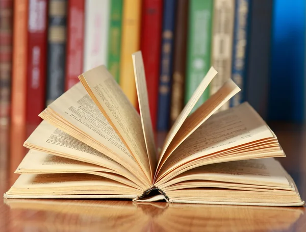 Livro na mesa contra livros . — Fotografia de Stock