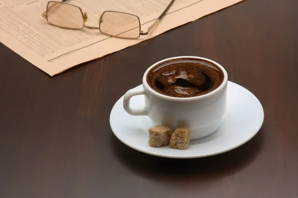 Чашка кофе возле ноутбука и газет . — стоковое фото